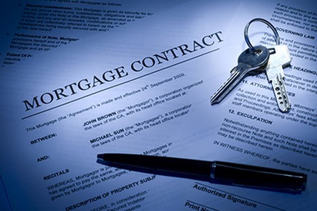 mortgage contract with keys and a pen laying on top of the papers